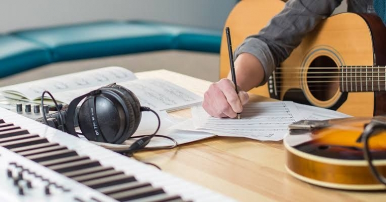 Ilustrasi proses kreatif menulis lagu dengan alat tulis dan inspirasi