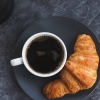 Sepotong Croissant dan Black Coffee